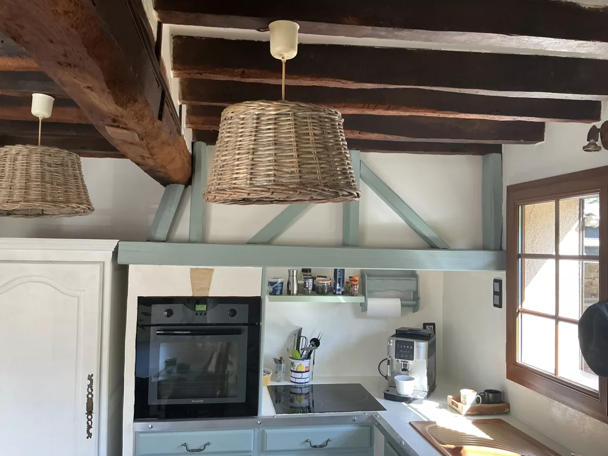 Ancienne configuration de la zone de cuisson sous les poutres avec les teintes vertes d'origine.